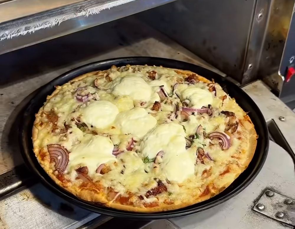 Pizza mit Hähnchenfleisch und Crème fraîche in der Form